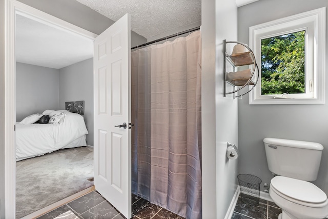 bathroom featuring a shower with curtain, a textured ceiling, and toilet