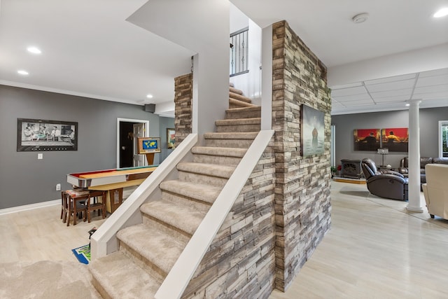 stairs with hardwood / wood-style flooring, decorative columns, and ornamental molding