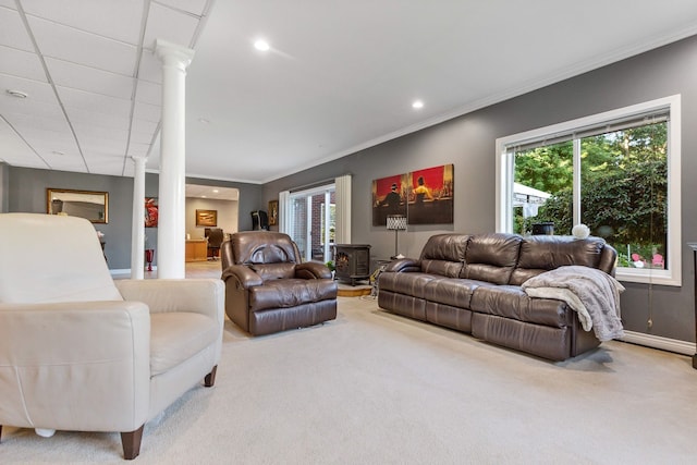 carpeted living room featuring decorative columns, a drop ceiling, and ornamental molding