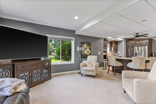 living room featuring light carpet, ceiling fan, and ornamental molding