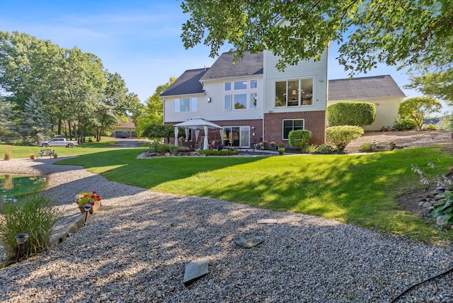 rear view of house featuring a lawn and a gazebo