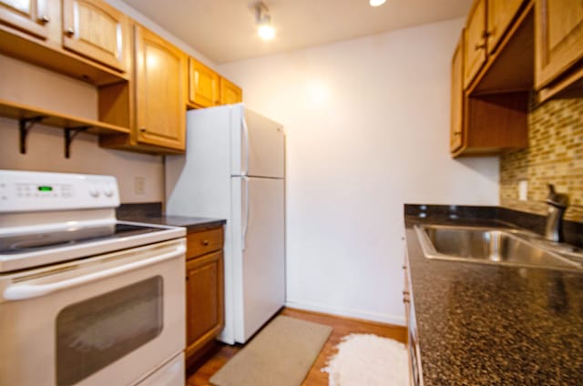 kitchen featuring backsplash, sink, and white appliances