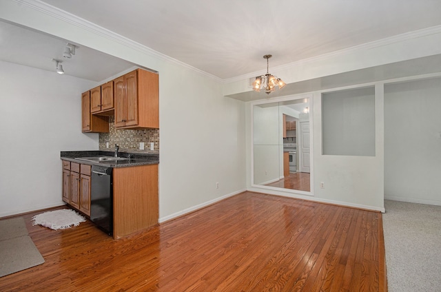 kitchen with decorative backsplash, sink, hardwood / wood-style flooring, an inviting chandelier, and dishwasher