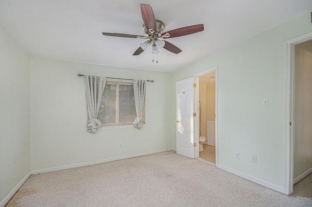 unfurnished bedroom featuring ceiling fan, light colored carpet, and ensuite bathroom