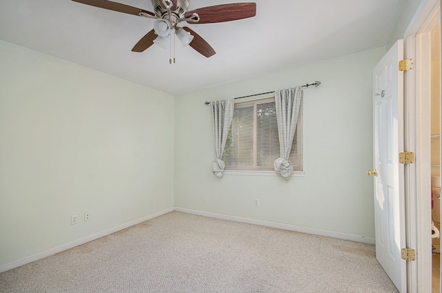 carpeted spare room featuring ceiling fan