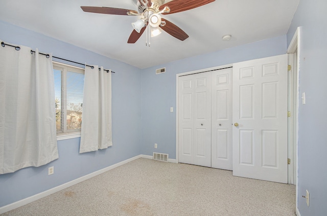 unfurnished bedroom featuring light carpet, a closet, and ceiling fan