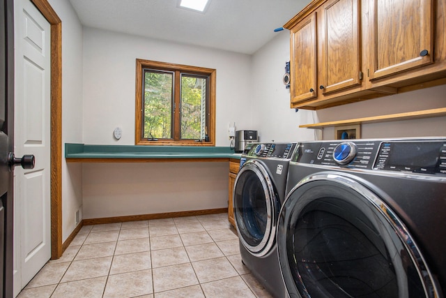 washroom with cabinets, light tile patterned floors, and washing machine and dryer