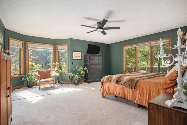 bedroom featuring a textured ceiling, light colored carpet, and ceiling fan