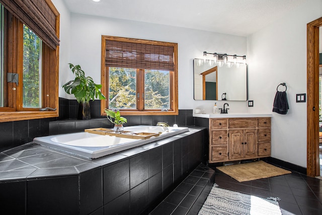 bathroom with tile patterned floors, vanity, and a healthy amount of sunlight