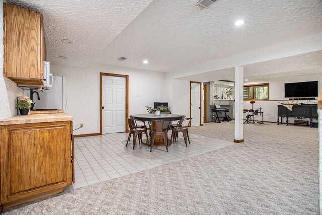 carpeted dining space with sink and a textured ceiling