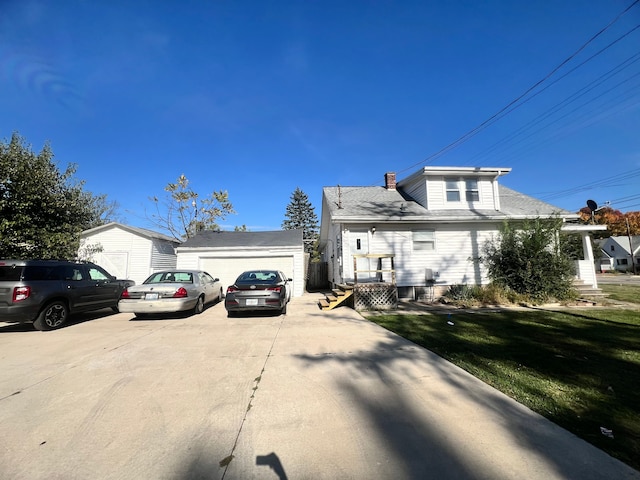 view of front facade featuring an outbuilding, a garage, and a front lawn