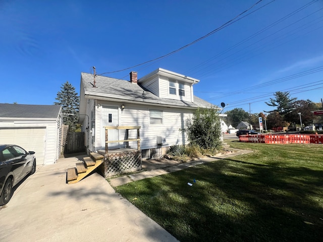 view of front of home featuring a garage, an outbuilding, and a front yard