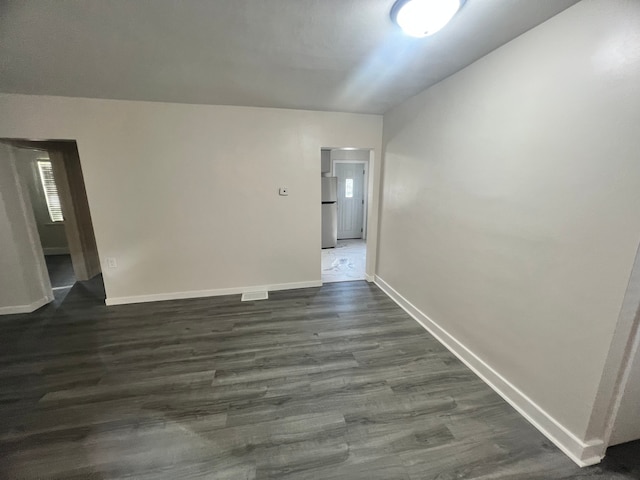 empty room featuring dark hardwood / wood-style flooring and lofted ceiling