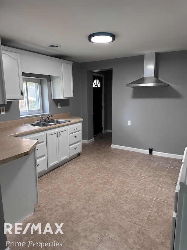 kitchen with white cabinetry, sink, and wall chimney exhaust hood