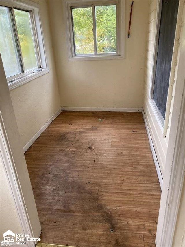 spare room with hardwood / wood-style floors and plenty of natural light