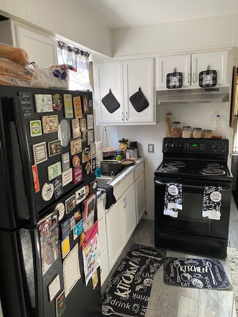 kitchen featuring white cabinets, exhaust hood, and black appliances