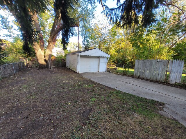15836 Patton St, Detroit, MI 48223 - view of yard with a garage, an outbuilding, and driveway
