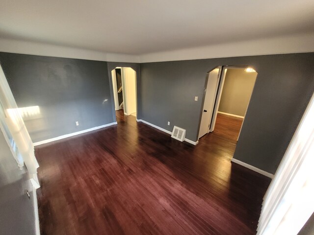 15836 Patton St, Detroit, MI 48223 - unfurnished room with arched walkways, wood finished floors, and baseboards