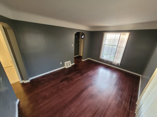 15836 Patton St, Detroit, MI 48223 - unfurnished room featuring arched walkways, wood finished floors, and baseboards