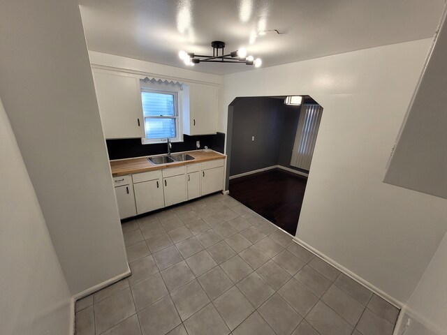 15836 Patton St, Detroit, MI 48223 - kitchen with a sink, white cabinets, light tile patterned floors, and baseboards
