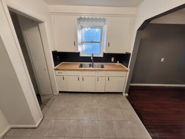15836 Patton St, Detroit, MI 48223 - kitchen featuring a sink, wood counters, light tile patterned flooring, and white cabinets