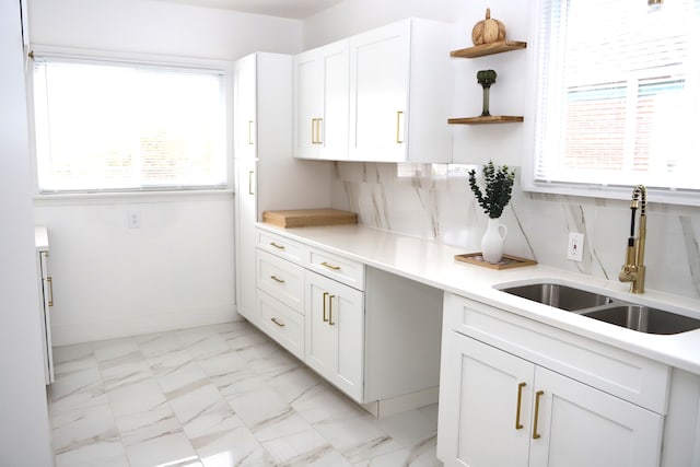 kitchen with white cabinets, sink, and tasteful backsplash