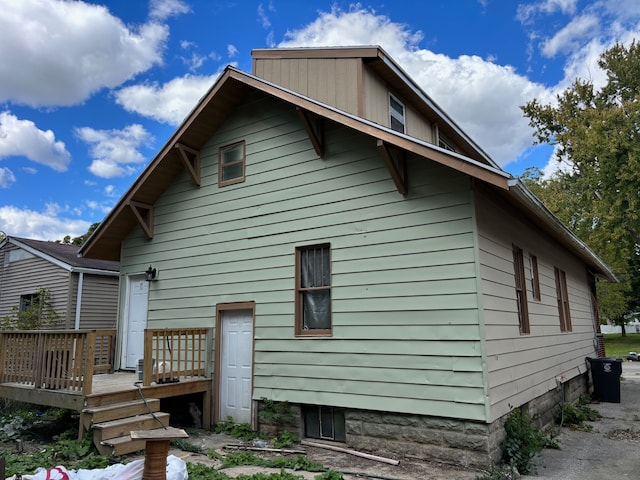 rear view of property featuring a wooden deck