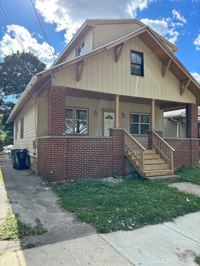 view of front facade with covered porch and brick siding