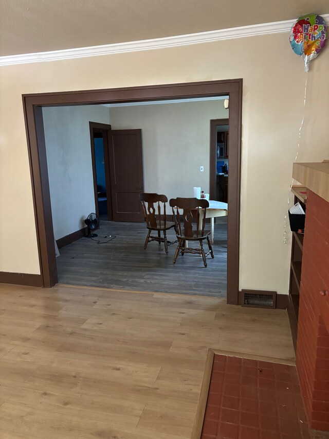 dining space featuring wood-type flooring and ornamental molding