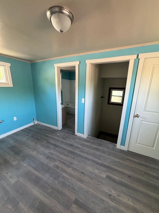 unfurnished bedroom featuring dark wood-type flooring, multiple windows, and a closet