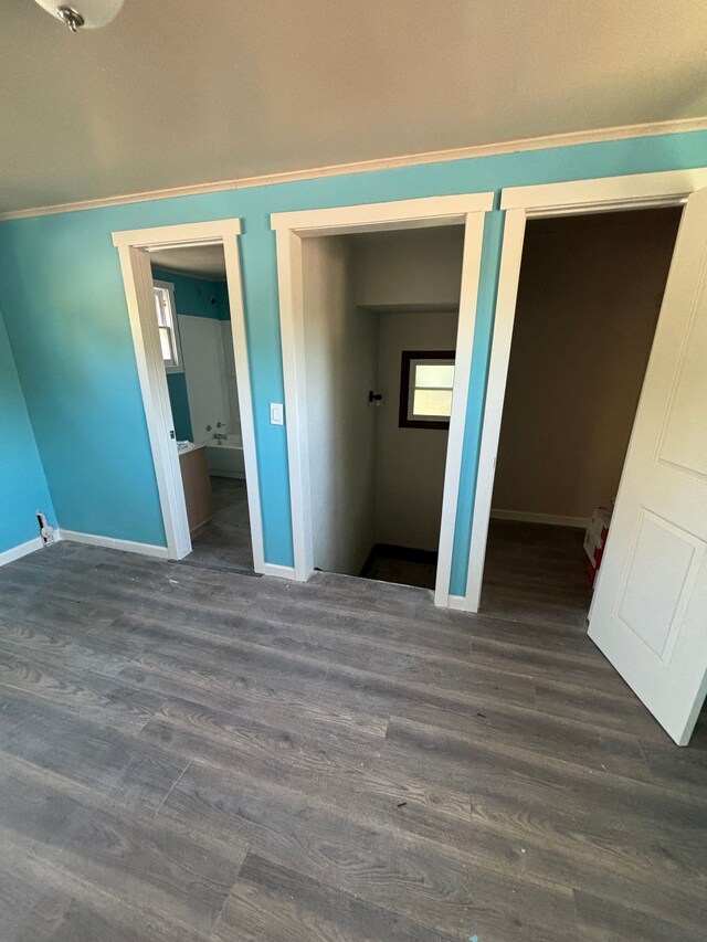 unfurnished bedroom with dark wood-type flooring and ensuite bathroom