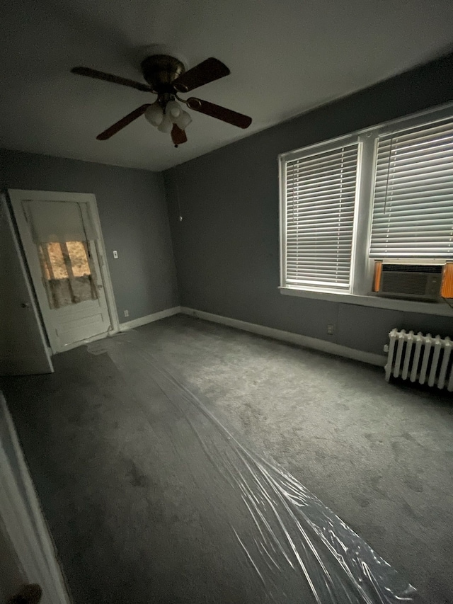 interior space featuring carpet, radiator heating unit, ceiling fan, and cooling unit