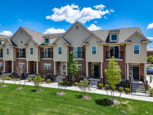 townhome / multi-family property featuring a front yard and cooling unit