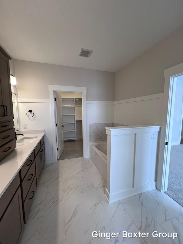 bathroom featuring a tub to relax in and vanity