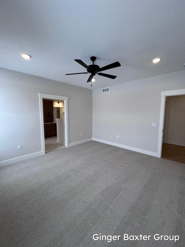 carpeted spare room featuring ceiling fan