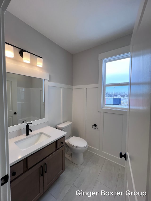 bathroom featuring walk in shower, vanity, and toilet