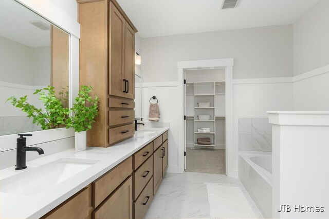 11376 Shoreline Dr Unit 115, Allendale, MI 49401 - bathroom with marble finish floor, double vanity, visible vents, a sink, and a bathing tub