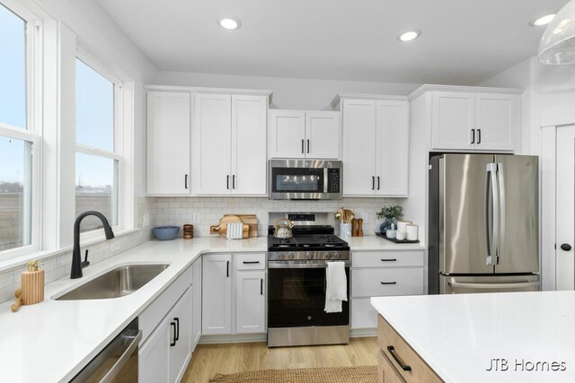 11376 Shoreline Dr Unit 115, Allendale, MI 49401 - kitchen with light countertops, white cabinetry, stainless steel appliances, and a sink