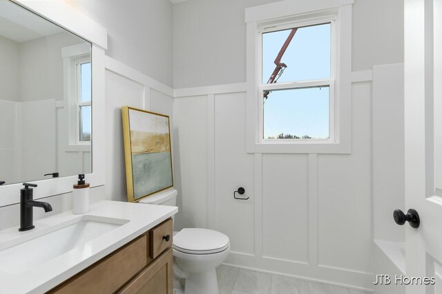 11376 Shoreline Dr Unit 115, Allendale, MI 49401 - bathroom featuring a decorative wall, vanity, walk in shower, a wainscoted wall, and toilet