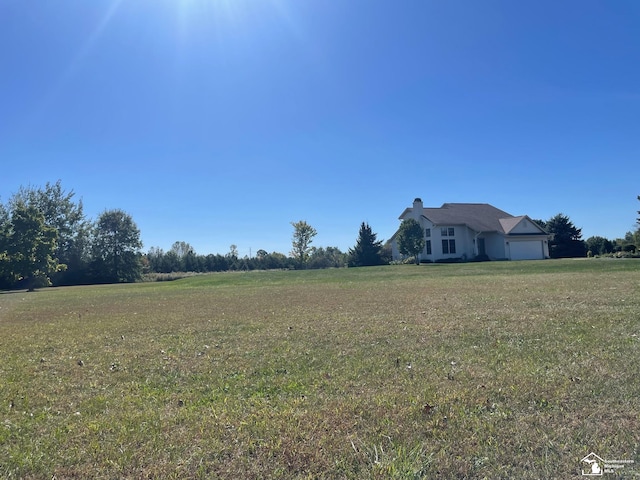 view of yard featuring a rural view and a garage