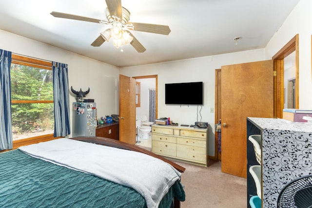 carpeted bedroom featuring ceiling fan, ensuite bath, and water heater