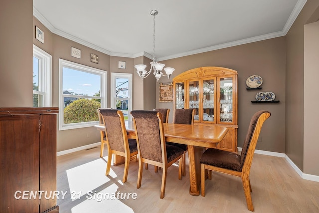 dining room featuring light hardwood / wood-style floors, an inviting chandelier, and ornamental molding