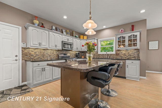 kitchen featuring decorative backsplash, light wood-type flooring, stainless steel appliances, and a kitchen island