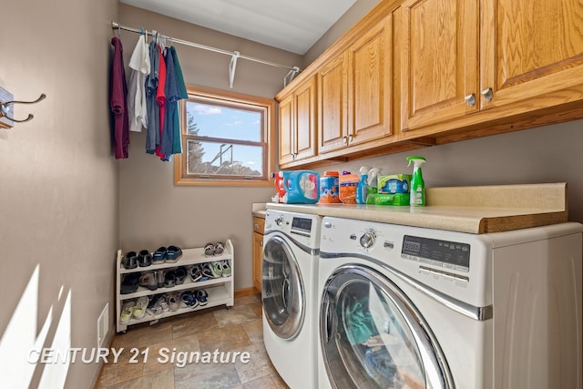 clothes washing area featuring cabinets and washing machine and dryer