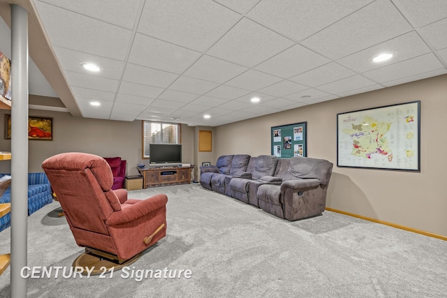 living room featuring carpet flooring and a drop ceiling