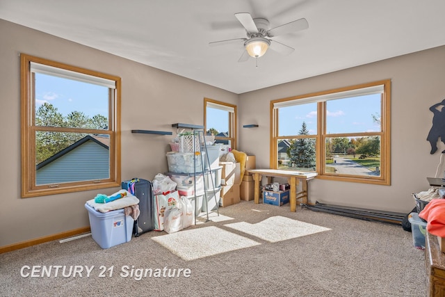 recreation room with carpet flooring, ceiling fan, and a healthy amount of sunlight