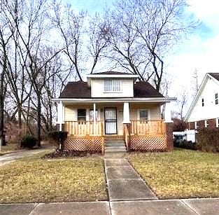 bungalow-style home with covered porch and a front yard