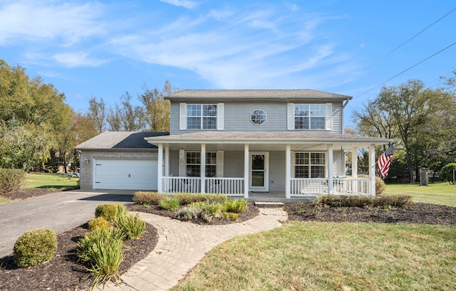 farmhouse with covered porch, a front yard, and a garage