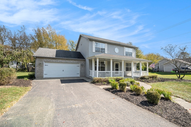 view of front of property with covered porch, a garage, and a front lawn