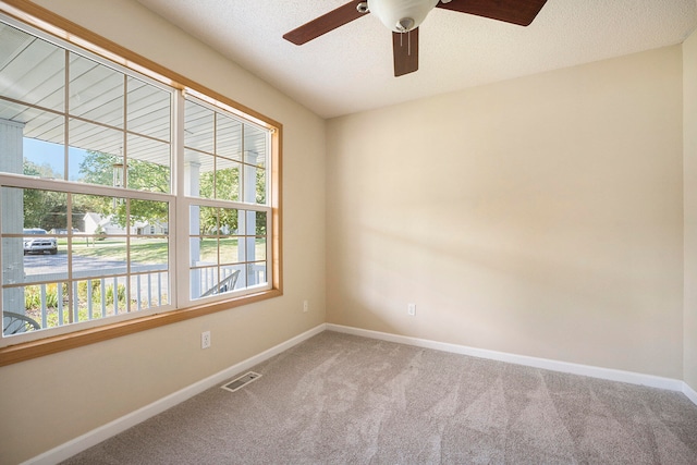 unfurnished room with ceiling fan, carpet, and a textured ceiling